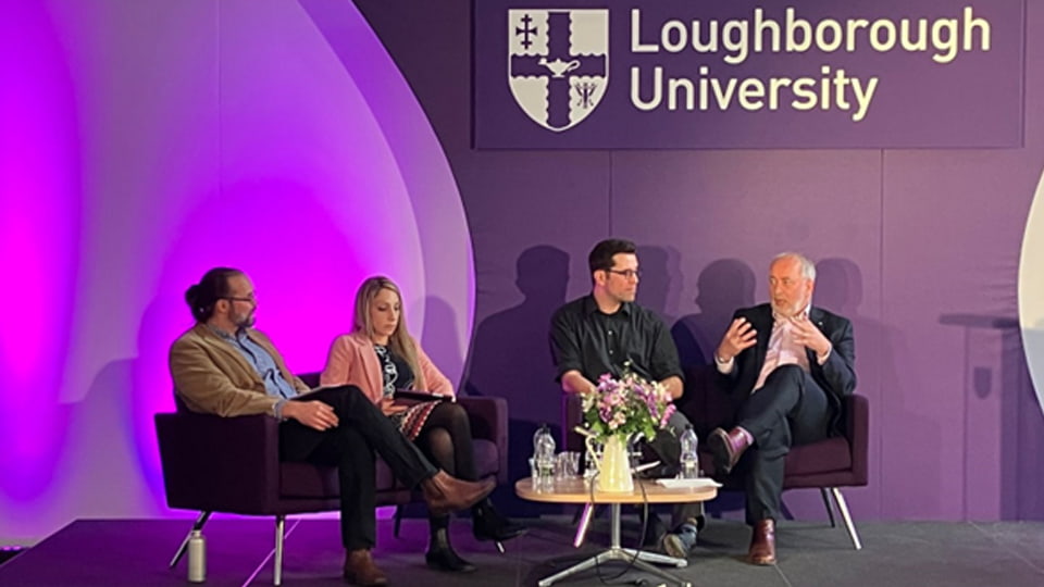 The four AI panellists seated against a purple backdrop with the university logo on the wall. 
L-R: Dr Martin Sykora, Dr Georgina Cosma, Dr Saul Albert, and Professor Nick Jennings.