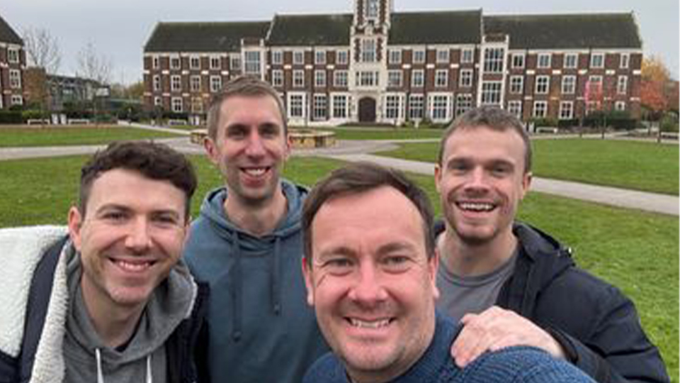 An image of Nick, Bradley, Joe and Mark at the Loughborough Campus with the Hazelrigg building in the background