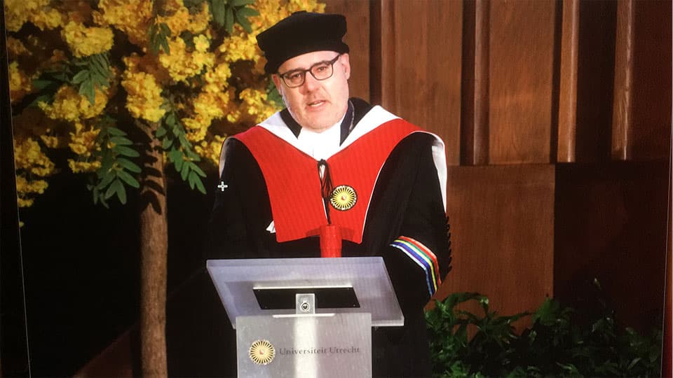 Matthew Flinders on stage wearing academic dress at Utrecht University receiving an honorary doctorate