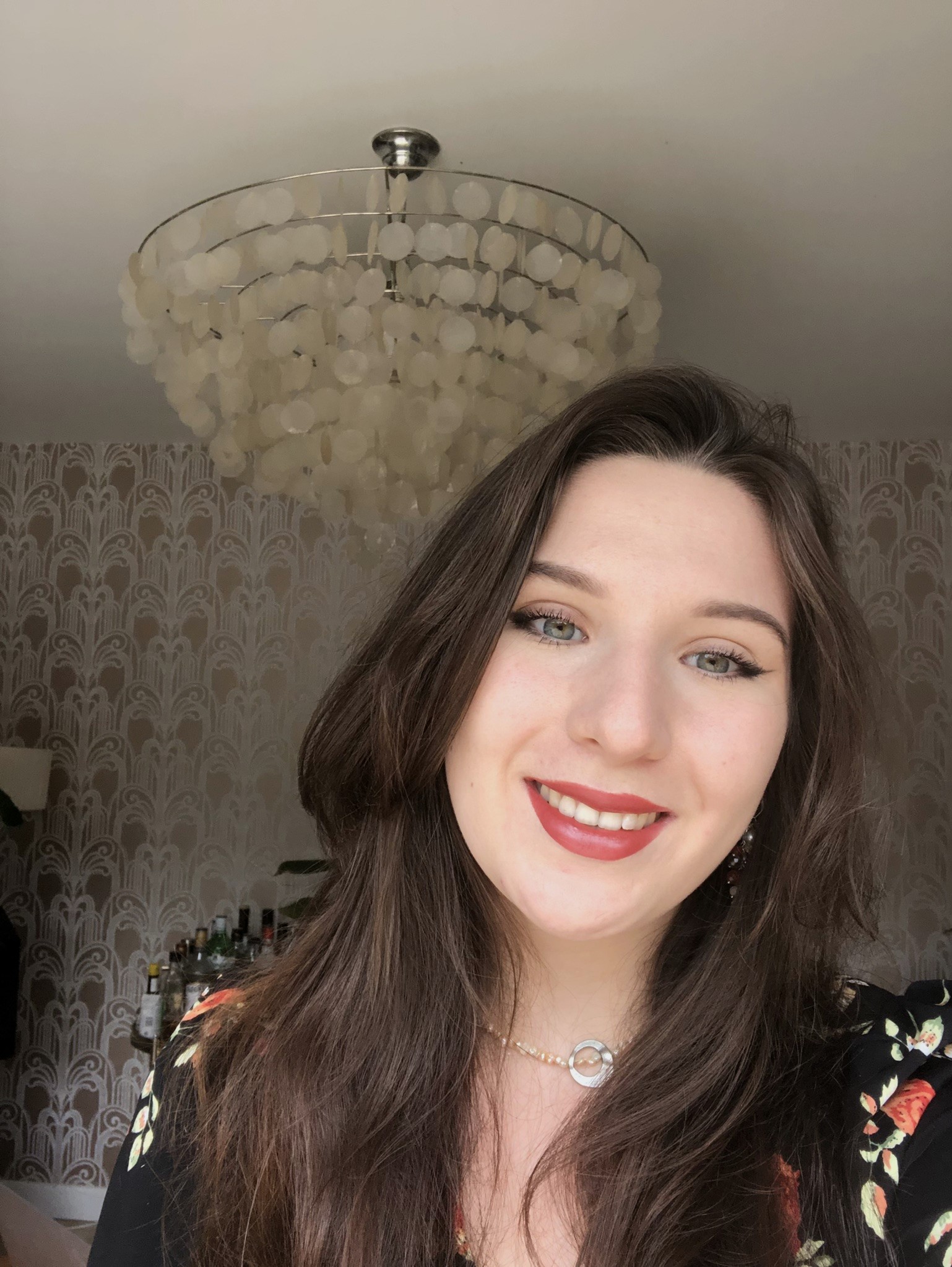 Charlotte, a female student with long brown hair smiles at the camera