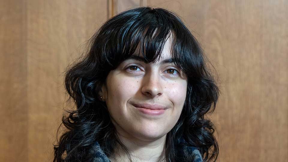 Young female of mixed ethncity with long black wavy hair with fringe
