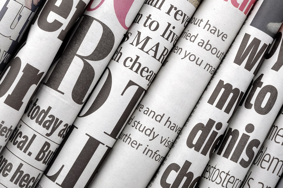 A selection of newspapers, stacked together.