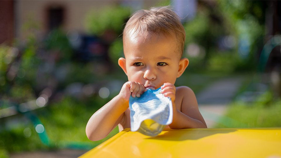 toddler eating from a food pouch