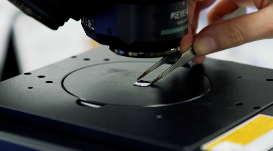 The chip bearing the image of ‘the world’s smallest violin’ is positioned under a microscope, as the intricate structure is only visible at high magnification.