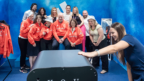 12 members of staff from Loughborough University in a photobooth wearing presentation jackets and bucket hats at Kitting Out for ParalympicsGB.