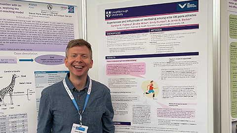 Dr Jamie Barker stood next to a research poster at FEPSAC in Austria