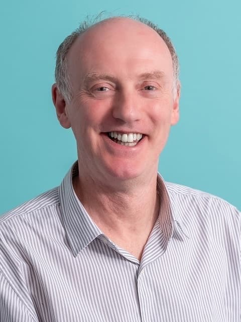 Headshot of Gary smiling in striped shirt