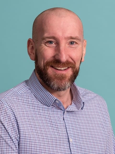 Headshot of Scot in blue checkered shirt