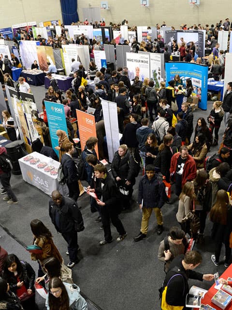 Students wandering around a hall of exhibitors and stalls.