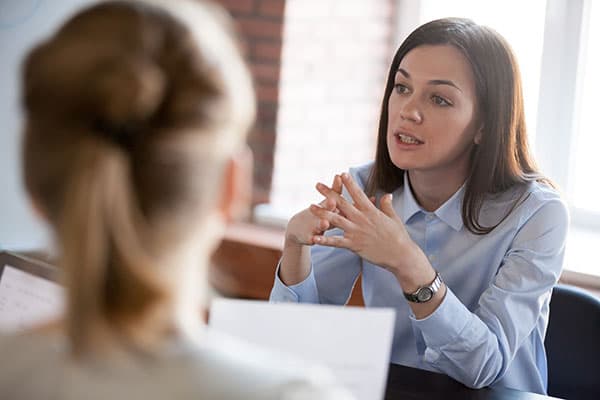 A person dressed smartly having a discussion with someone off camera.