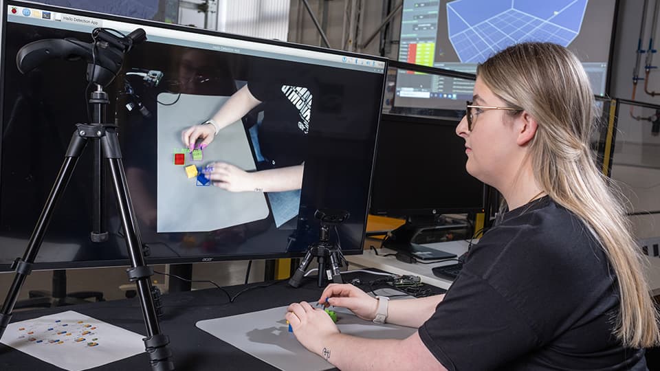 An engineering student working with lego and a computer