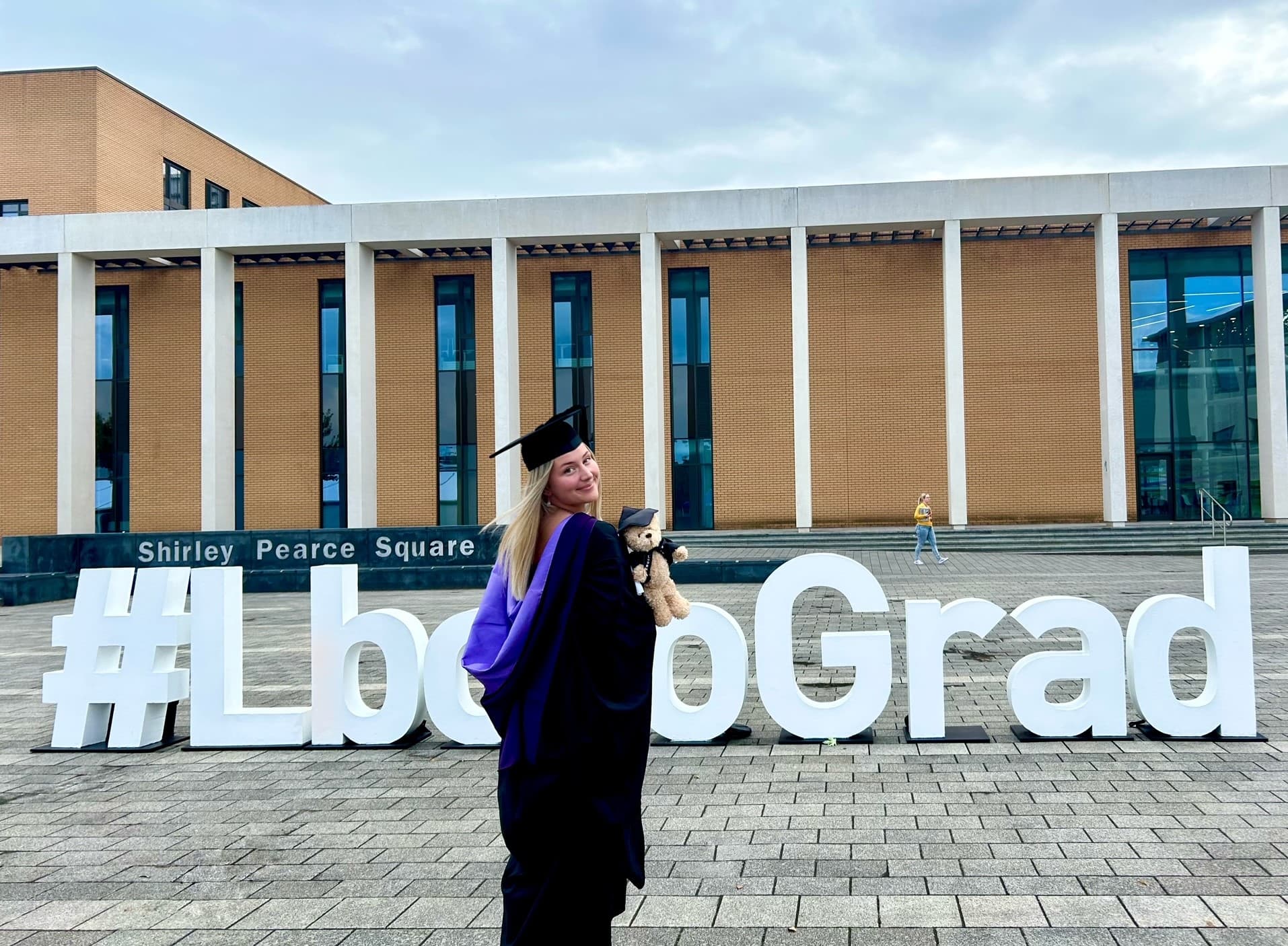 Lottie in her graduation gown outside a University building