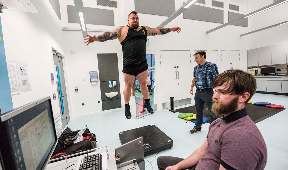 Deadlift champion Eddie Hall pictured mid-jump on a force plate while Loughborough University sport scientists monitor him
