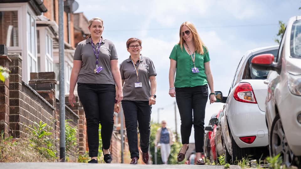 Three community wardens walk down a street of a popular student accommodation area in Loughborough town