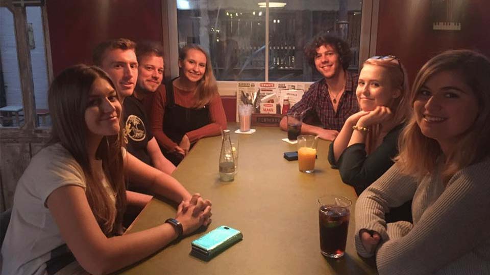 Hannah and six of her friends at a restaurant. 