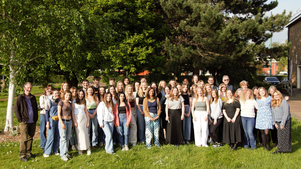 English students and staff stanfing outside in the sunshine