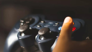 a close up photo of a game controller being held in a child's hand