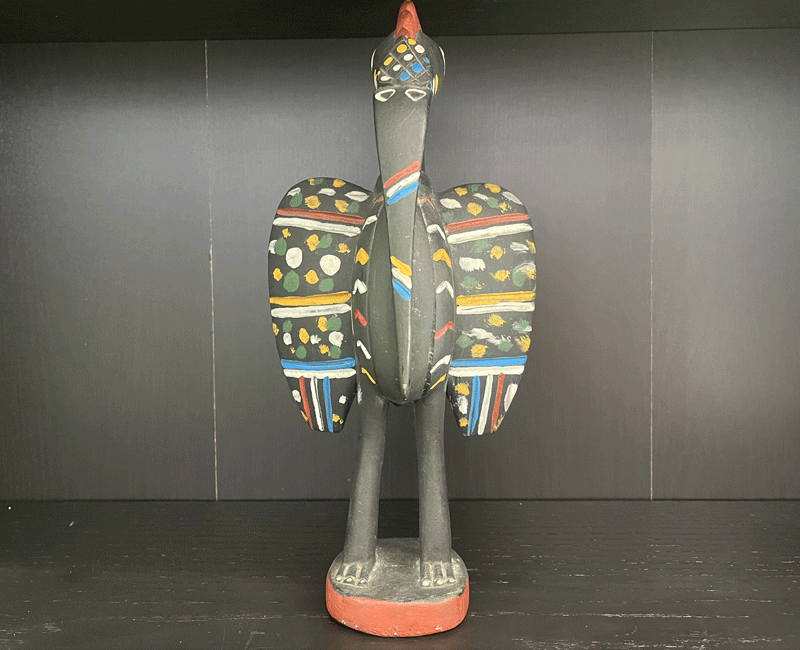 a black statue of a bird with colourful patterns