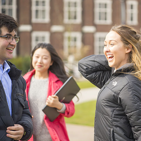 Smiling students outside Hazlerigg building