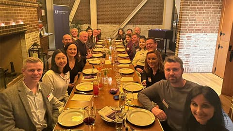 A group of Loughborough alumni, staff, along with Professor Nick Jennings, Vice-Chancellor and President of Loughborough University at a restaurant sitting round a table in Chicago. They are smiling at the camera.