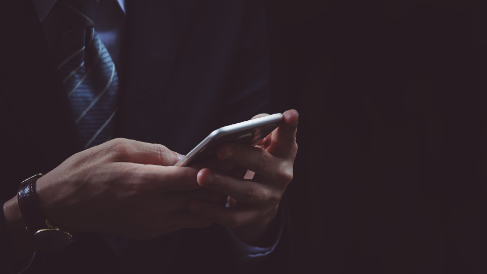 Man in suit holding mobile 