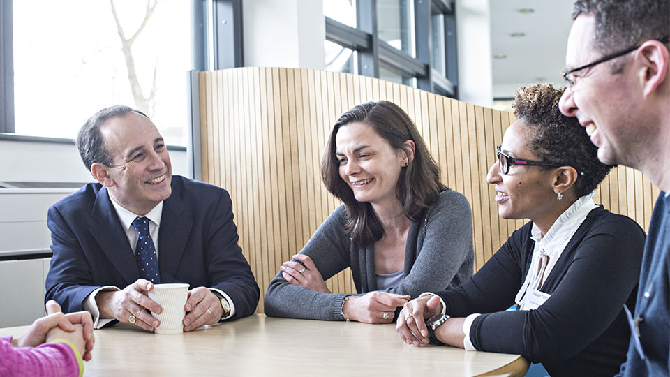 Pictured are business people talking round a table. 