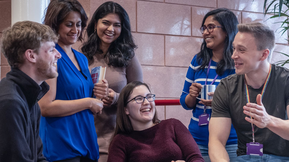 A group of LUinc. members - sitting at a table, chatting and laughing