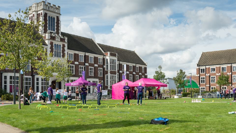 People playing outdoor games on the grass in front of the Hazlerigg building. 