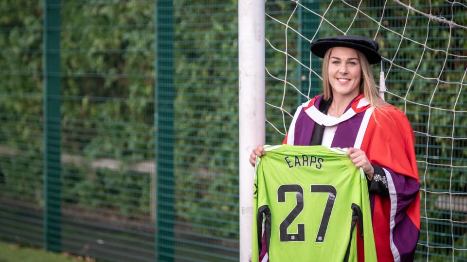 Mary Earps holding a football shirt