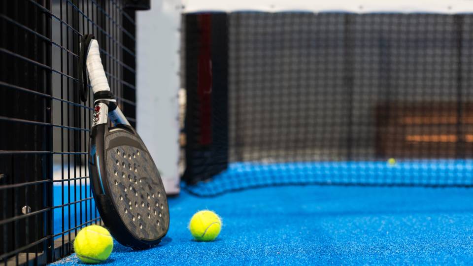 a padel racket leaned against a wall