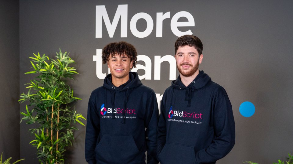 Henry Brogan and Tyler McCarthy standing together wearing BidScript hoodies.