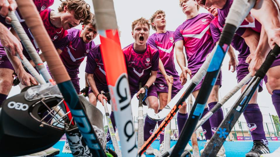 hockey players in a huddle shouting encouragement