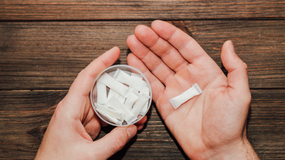 a person holding a tin of snus