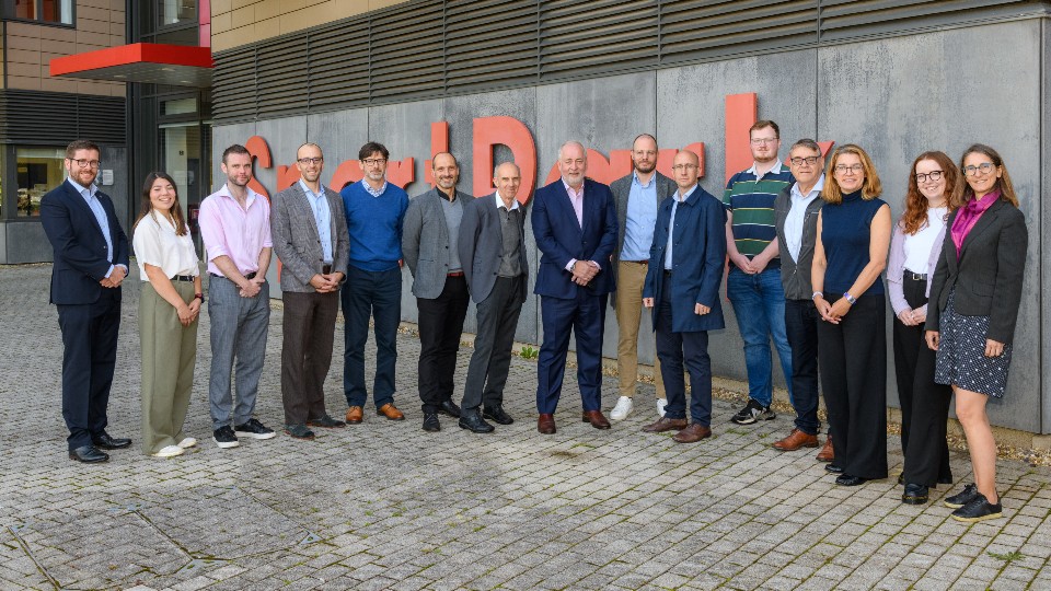 Delegates including Vice-Chancellor Professor Nick Jennings, Nico Perins and Andrew Cooke, stand outside SportPark.