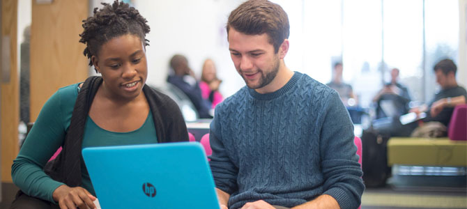 Essential info header - couple of students at a laptop