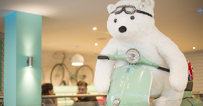 Photograph of polar bear teddy riding a scooter